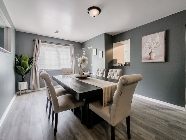 dining space featuring visible vents, baseboards, and wood finished floors