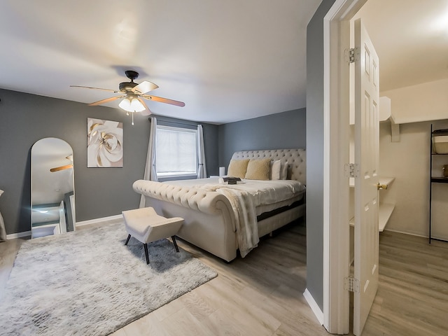 bedroom featuring ceiling fan, baseboards, and wood finished floors