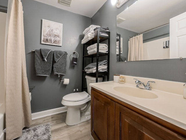 bathroom featuring visible vents, baseboards, toilet, and wood finished floors