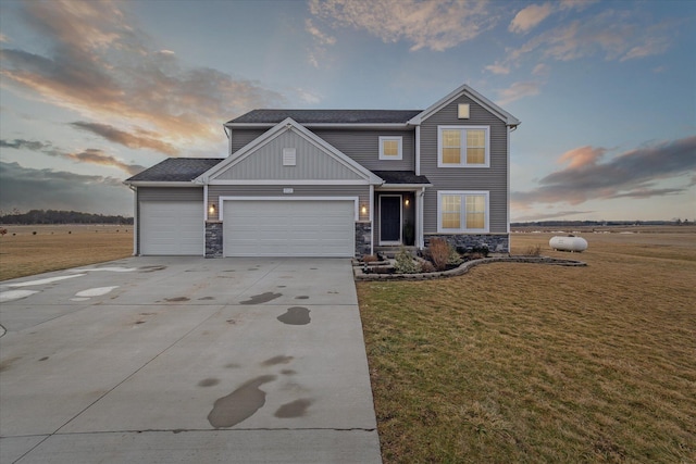 craftsman-style home with a garage, stone siding, concrete driveway, and a front lawn