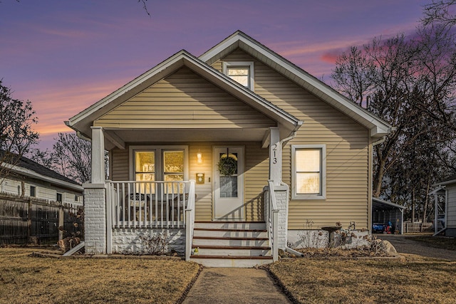 bungalow with covered porch and fence