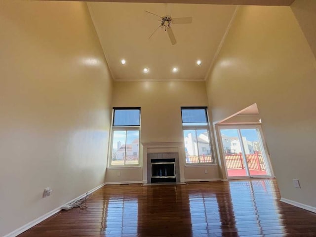 unfurnished living room with hardwood / wood-style floors, high vaulted ceiling, ornamental molding, and ceiling fan