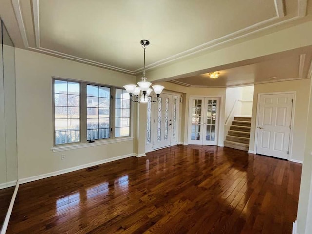 unfurnished dining area featuring visible vents, hardwood / wood-style flooring, french doors, an inviting chandelier, and baseboards