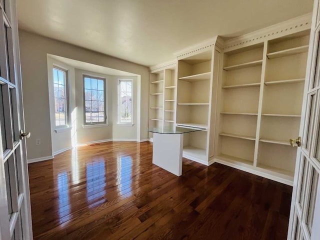 interior space featuring dark wood-type flooring and baseboards