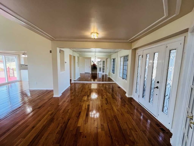 entrance foyer featuring a notable chandelier, crown molding, baseboards, and hardwood / wood-style floors