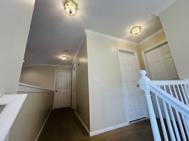 corridor featuring an upstairs landing, carpet flooring, baseboards, and ornamental molding