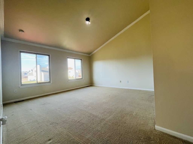 carpeted empty room with vaulted ceiling, visible vents, baseboards, and ornamental molding