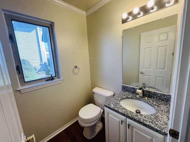 half bathroom with vanity, wood finished floors, baseboards, crown molding, and toilet