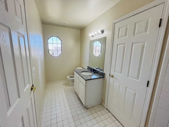 half bath featuring vanity, baseboards, visible vents, tile patterned floors, and toilet