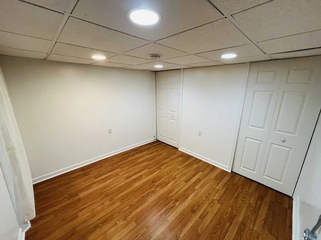 finished basement featuring recessed lighting, a drop ceiling, baseboards, and wood finished floors