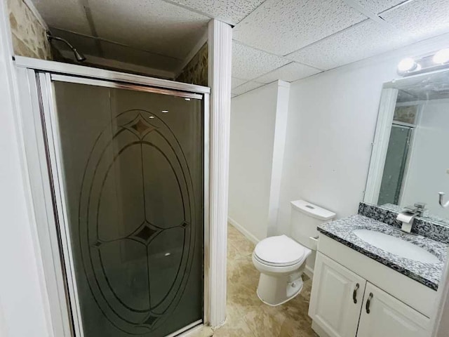 full bathroom with a paneled ceiling, toilet, a stall shower, and vanity