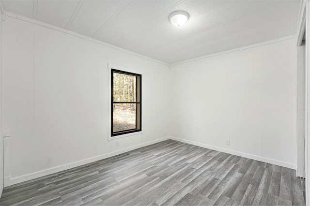 unfurnished room with baseboards and wood finished floors