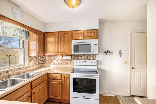 kitchen featuring white appliances, visible vents, a sink, light countertops, and tasteful backsplash