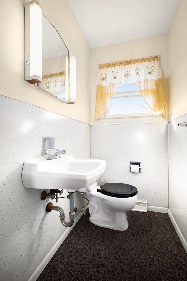 bathroom featuring a baseboard radiator, toilet, baseboards, and a sink