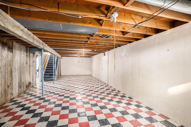 unfinished below grade area featuring tile patterned floors and stairway