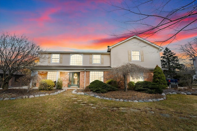 traditional home featuring a yard, french doors, and brick siding