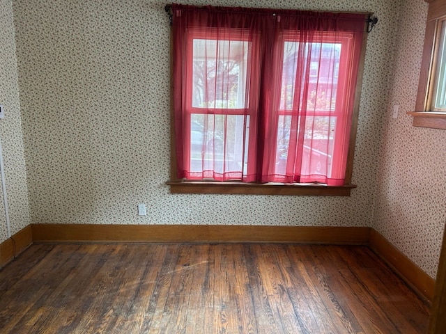 1406 W Ottawa St W, Lansing, MI 48915 - empty room with wood finished floors, baseboards, and wallpapered walls