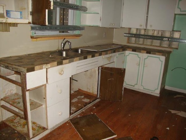 kitchen with dark wood-style flooring, open shelves, white cabinetry, and a sink