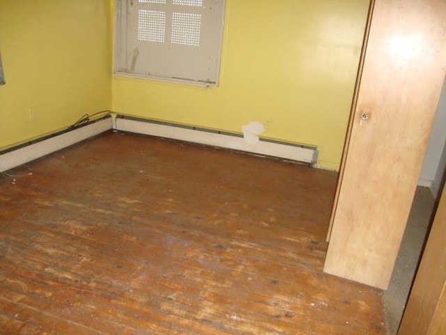 unfurnished room featuring a baseboard radiator and hardwood / wood-style flooring