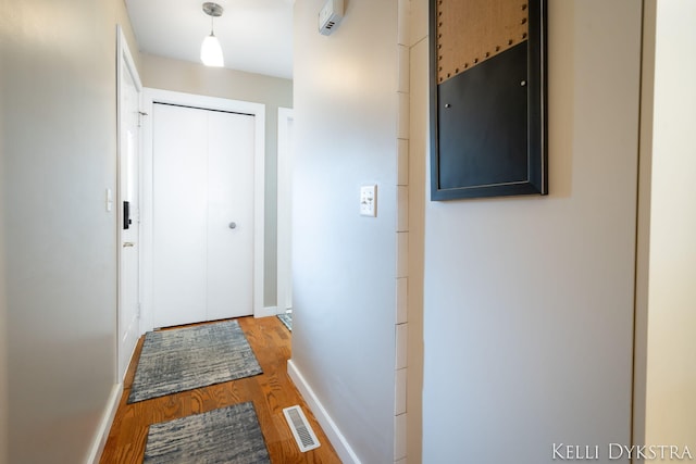 interior space with wood finished floors, visible vents, and baseboards