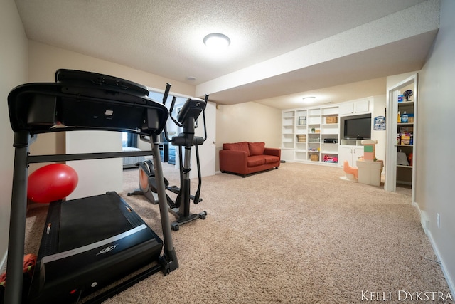 workout room featuring carpet and a textured ceiling