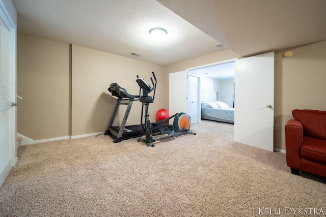 exercise area with carpet, visible vents, and a textured ceiling