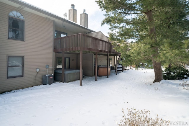 yard covered in snow featuring cooling unit and a hot tub