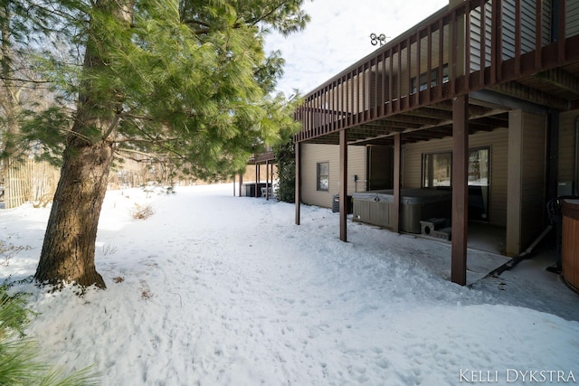 yard covered in snow featuring a hot tub