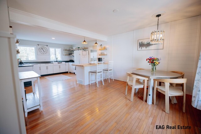 dining room featuring light wood finished floors and an inviting chandelier