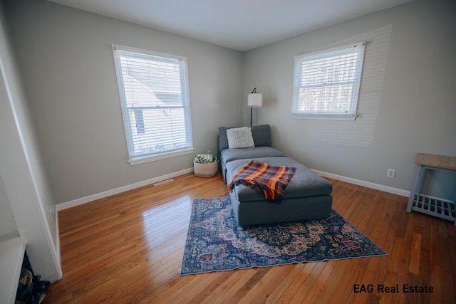 sitting room with baseboards, a healthy amount of sunlight, and hardwood / wood-style flooring