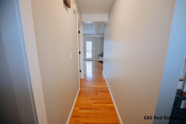 hallway with light wood finished floors and baseboards