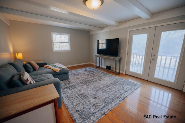 living area featuring visible vents, baseboards, light wood finished floors, french doors, and beamed ceiling