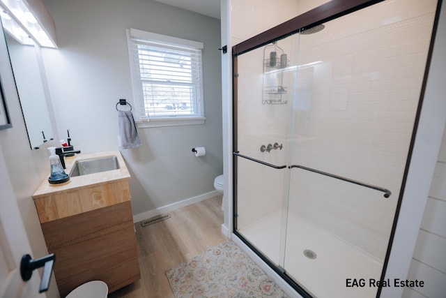 full bathroom featuring visible vents, toilet, a stall shower, baseboards, and vanity