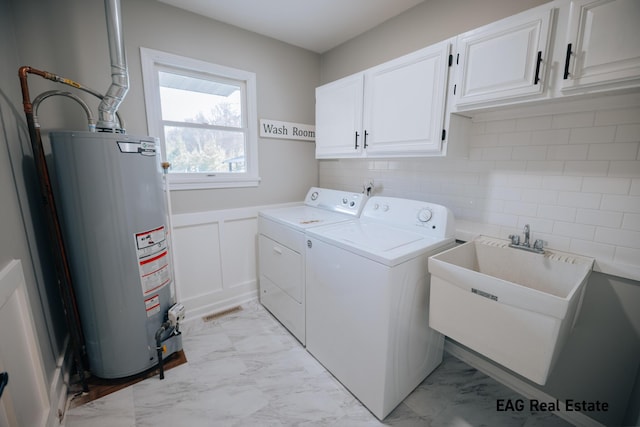 laundry room featuring marble finish floor, a sink, gas water heater, cabinet space, and washing machine and clothes dryer