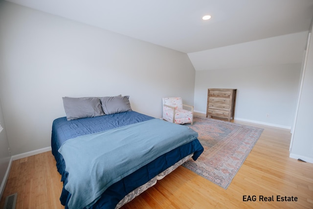 bedroom featuring visible vents, wood finished floors, recessed lighting, baseboards, and vaulted ceiling