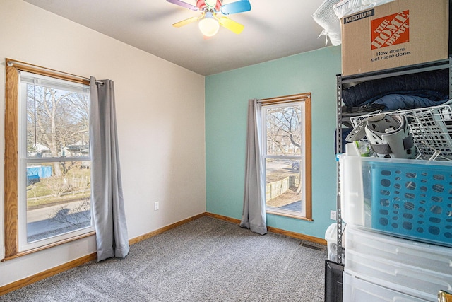 interior space with baseboards and a ceiling fan