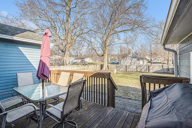 wooden deck with outdoor dining space, a fenced backyard, a lawn, and a residential view