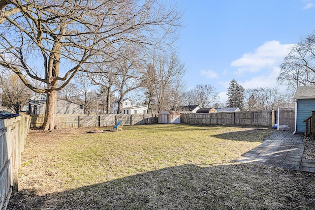 view of yard featuring an outbuilding, a storage shed, and a fenced backyard