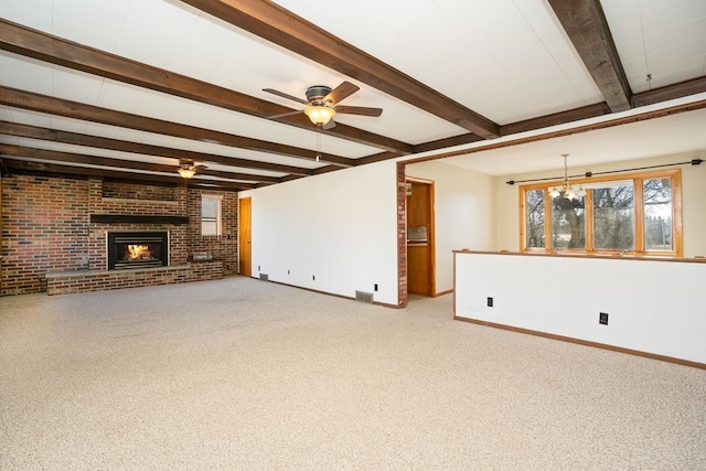 unfurnished living room with beam ceiling, a ceiling fan, brick wall, carpet flooring, and a fireplace