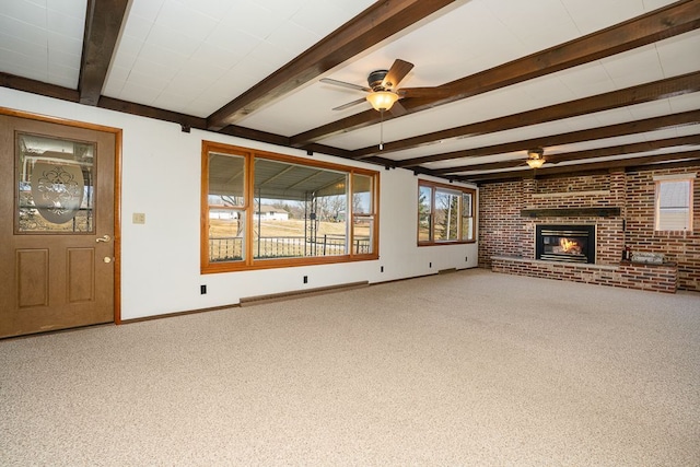 unfurnished living room with beamed ceiling, a fireplace, carpet, and ceiling fan