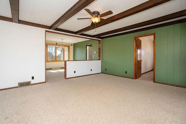 empty room featuring beam ceiling, carpet flooring, ceiling fan with notable chandelier, and visible vents