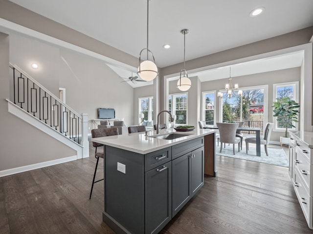 kitchen featuring light countertops, dark wood finished floors, a healthy amount of sunlight, and a sink