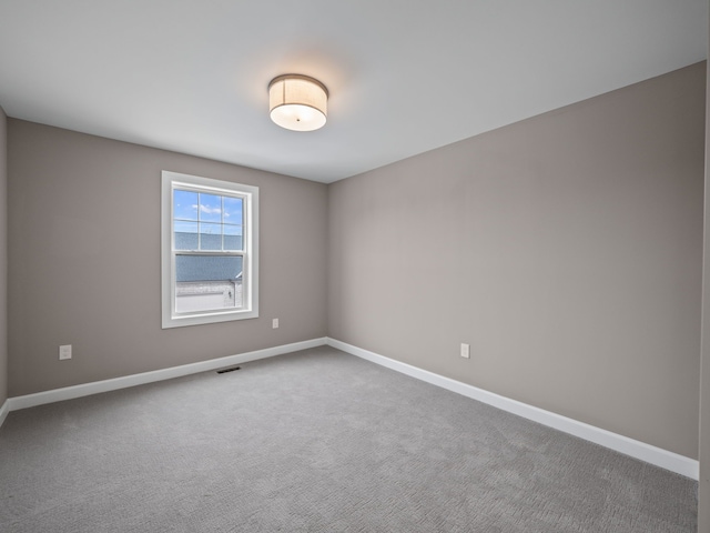 unfurnished room with baseboards, carpet flooring, and visible vents