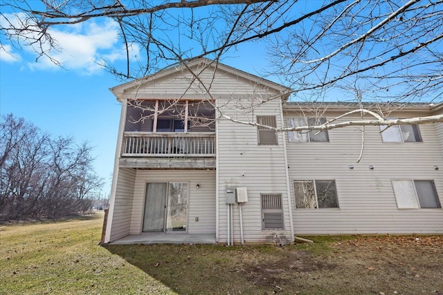 back of property with a lawn and a patio area