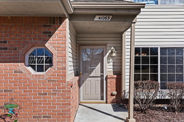 doorway to property with brick siding