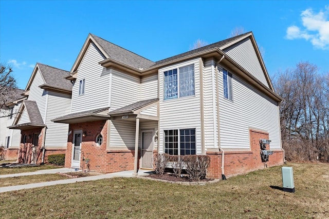 view of front of house featuring a front lawn and brick siding