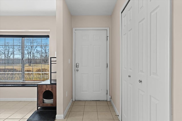 foyer entrance featuring light tile patterned floors and baseboards