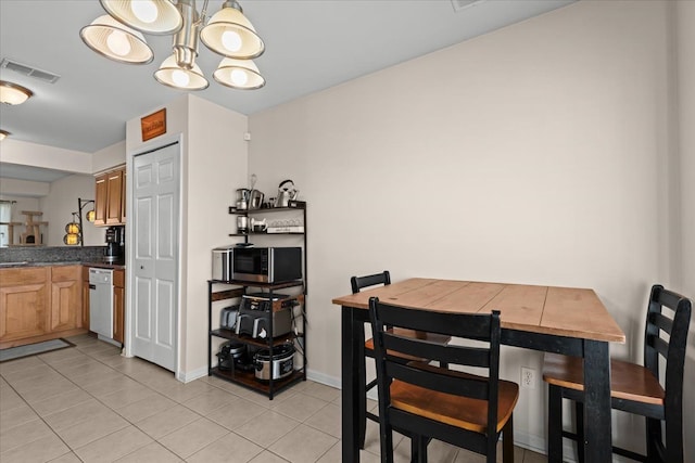 dining area with light tile patterned floors, visible vents, an inviting chandelier, and baseboards