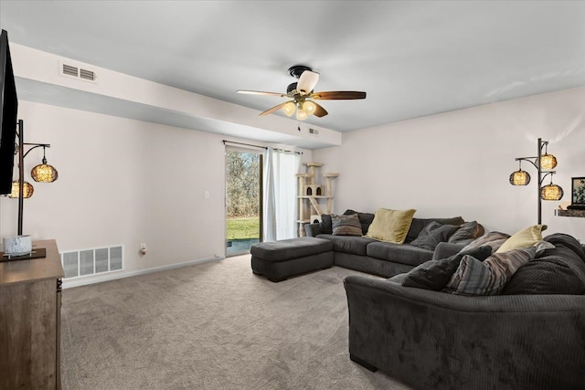 carpeted living room with visible vents, baseboards, and a ceiling fan