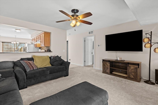 living room featuring light carpet, visible vents, ceiling fan with notable chandelier, and baseboards